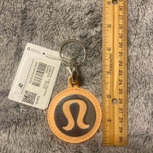 NWT Lululemon large logo mirrored keychain peach color, sealed in manuf. plastic